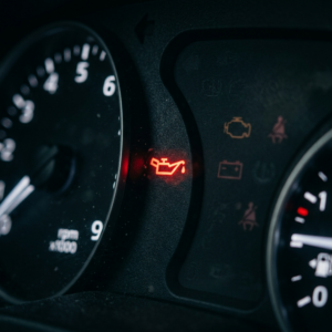 Testigo rojo iluminado de la lata de goteo de presión de aceite encendido en el panel de instrumentos del carro